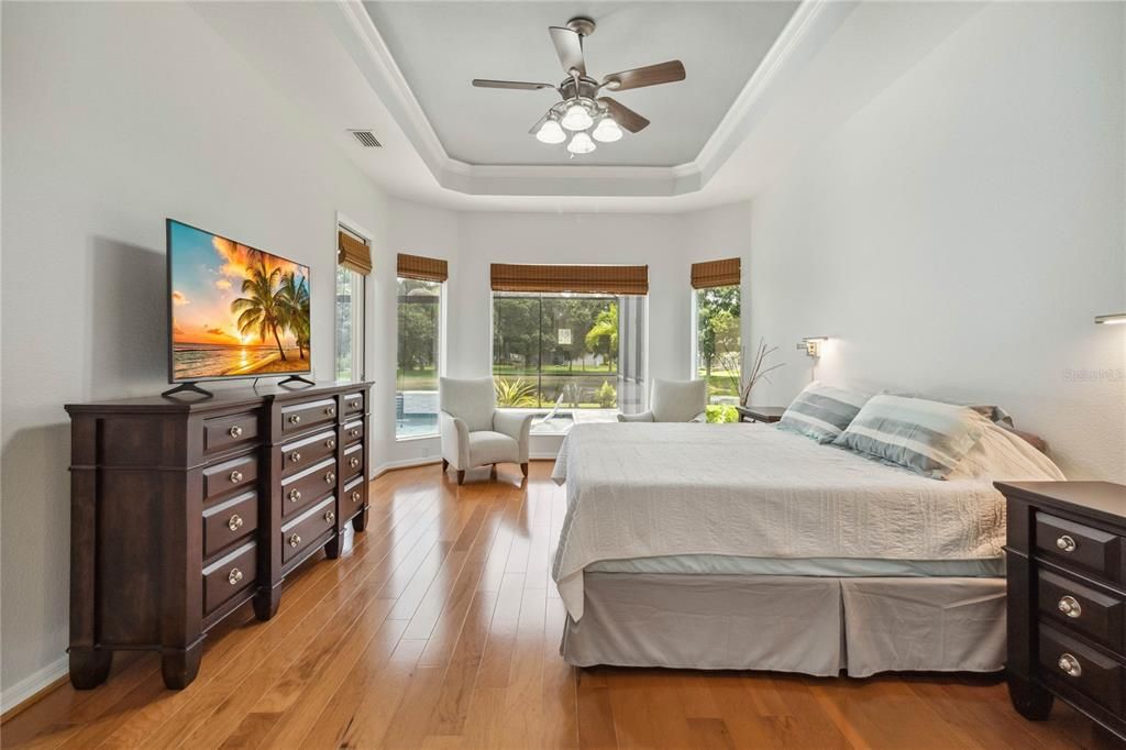 Primary suite has immense windows and high tray ceilings create a light-filled and airy retreat. A private door leads directly to the lanai, offering a seamless blend of indoor-outdoor living