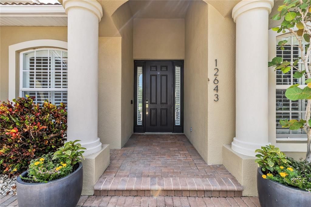 A grand entrance framed by two majestic pillars, welcoming you into this luxurious 4-bedroom, 3-bath custom estate home.