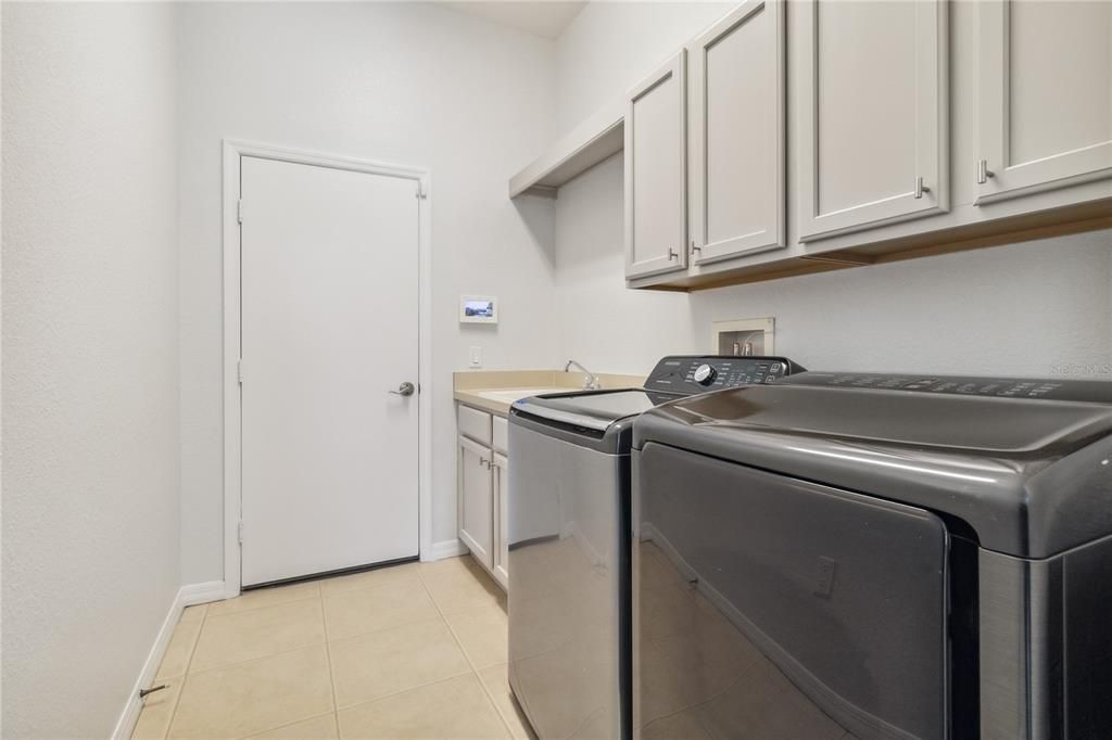 Utility Room connects to garage with oversized sink and cabinets for ample storage.