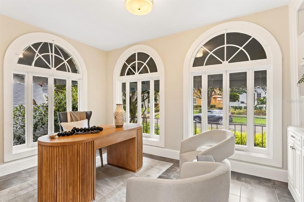 Front office with bay windows and a floor-to-ceiling bookshelf.