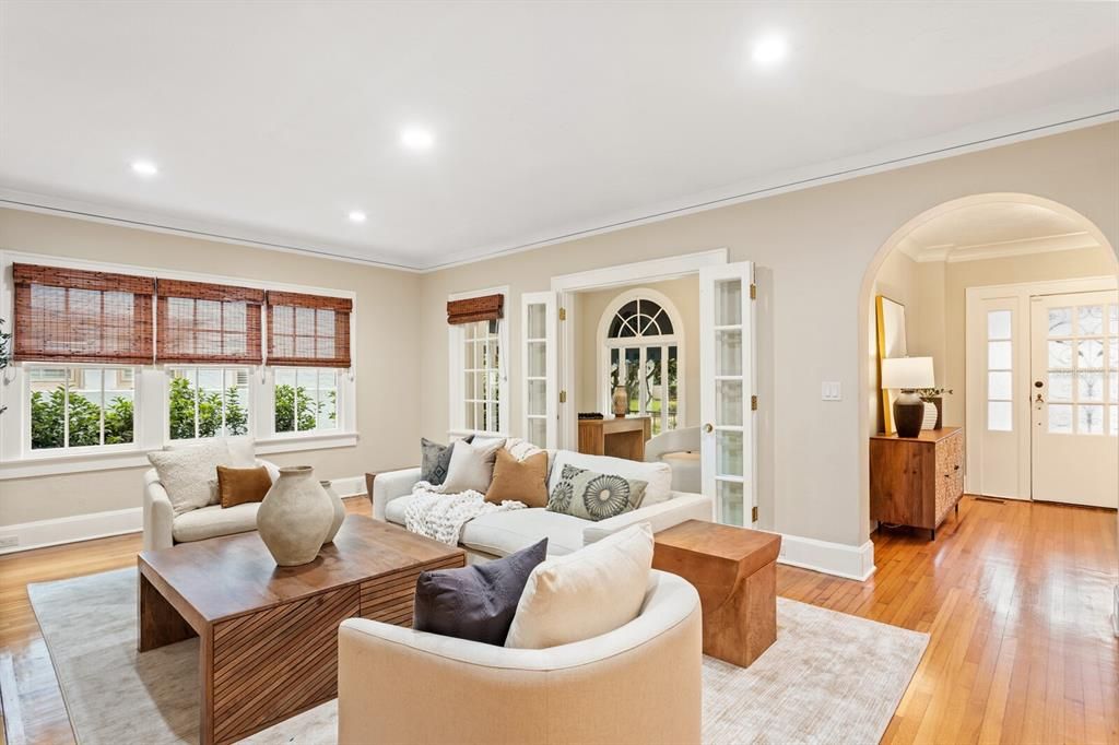 Living room provides access to the front office with accordion French doors.