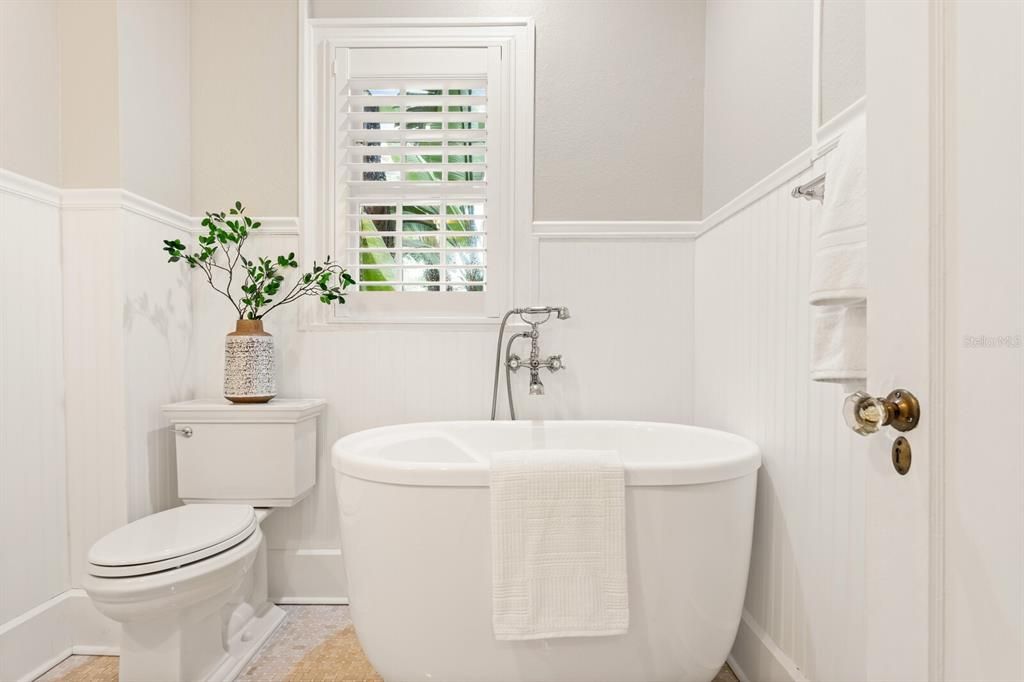 Adjacent to the downstairs bedroom is a full hall bath with vessel tub.