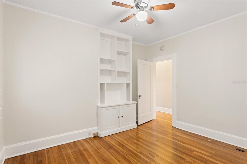 Main floor bedroom has a quaint built-in bookshelf.