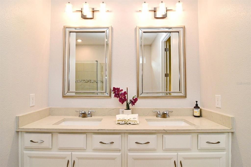 Primary Bath: double-sink vanity with quartz counter; decorative mirrors and lights