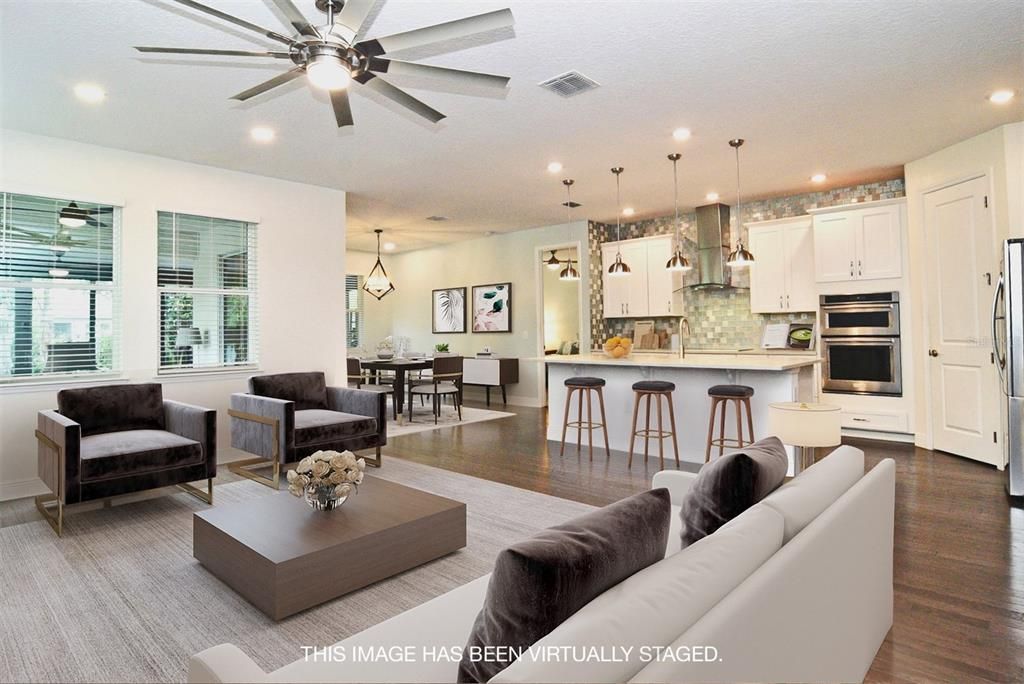 Great room, dining room and kitchen with wood flooring