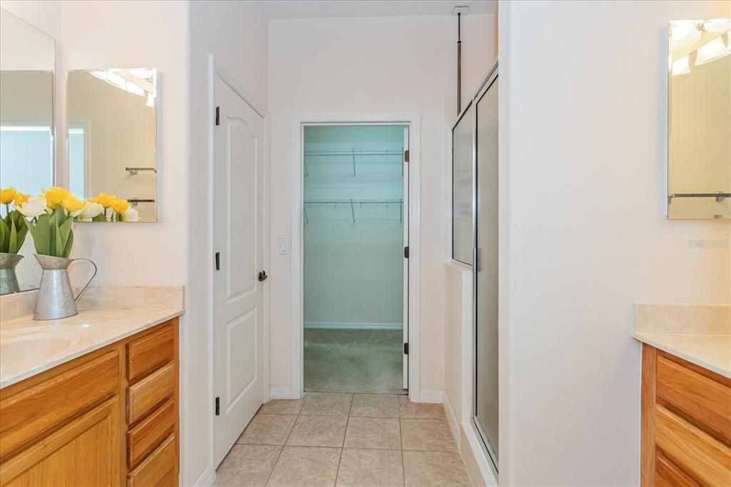 Primary bathroom with his and her vanities and walk-in closet