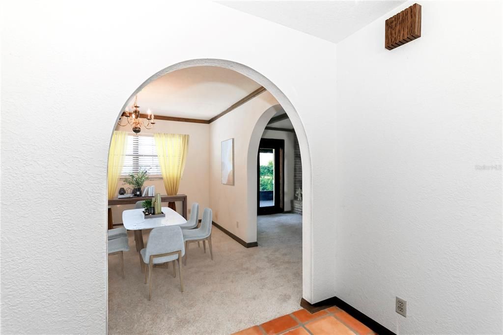 Dining room with arched walkways sites between kitchen and Family room