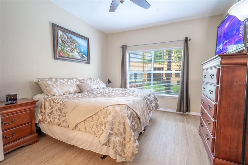 Bedroom 2 features luxury vinyl flooring, neutral tones and a ceiling fan with light kit.