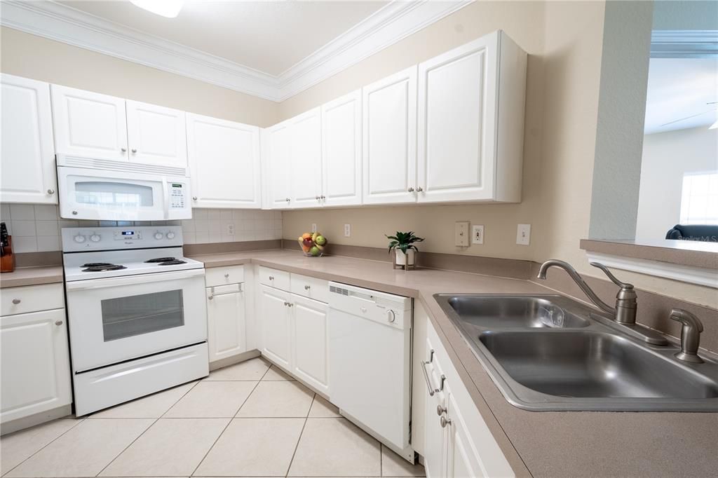 The kitchen features and abundance of cabinet and solid surface counter space. It has a double bowl stainless steel sink.