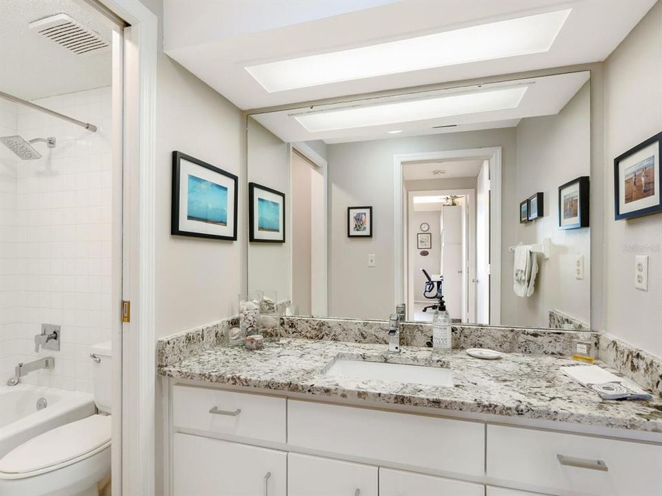 Guest bathroom - updated attractively w/granite counters, pocket door to toilet/tub. Solar tub sky light too.