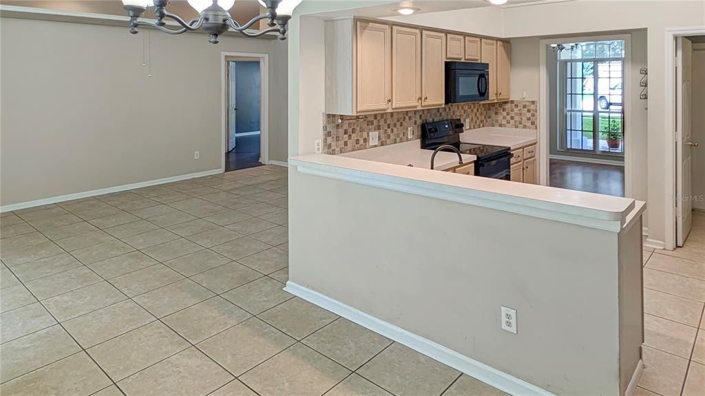 Living Room and Kitchen as seen from Eat-in Kitchen! Large Eat-In Kitchen with Breakfast Bar Overlook Lush Green Views of the FOREST Just on the Edge of Your Backyard!