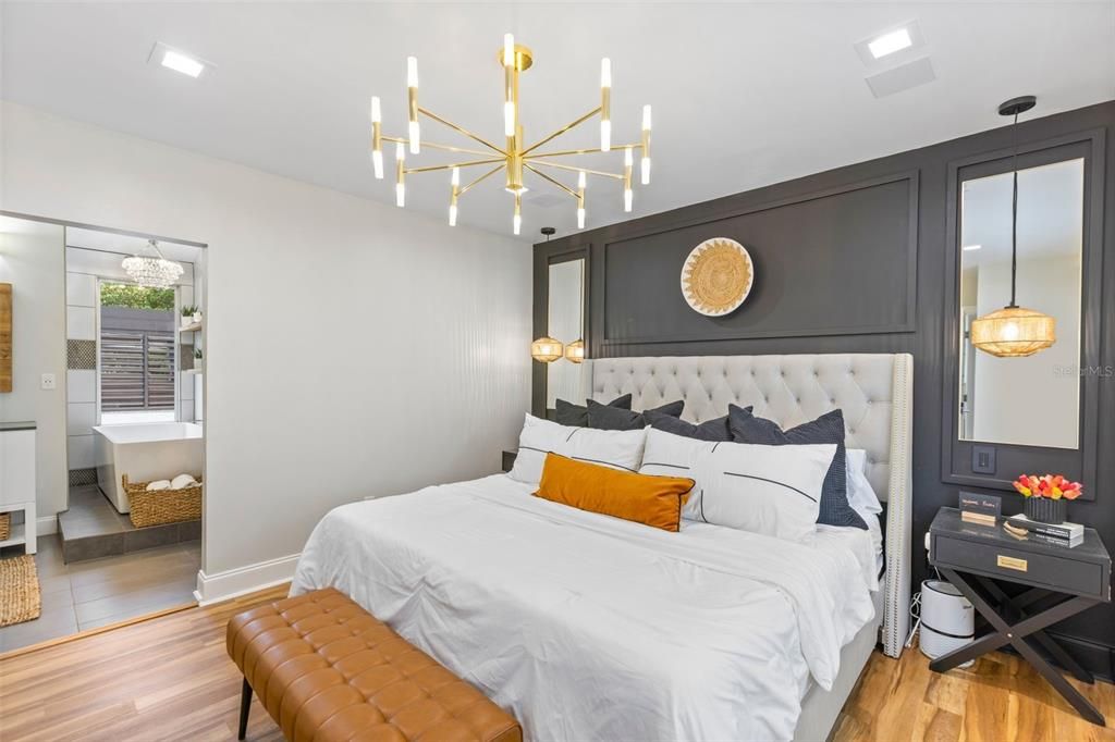 Primary Bedroom - wood trim designer wall, chandelier, hanging scones