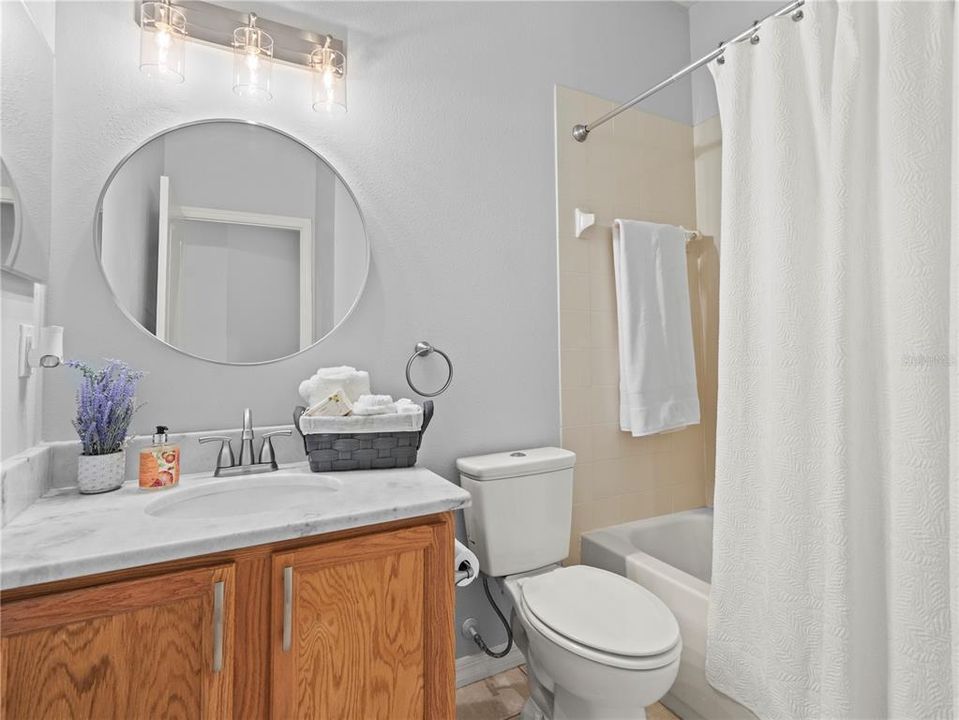 Guest Bathroom with tub and shower. New countertops and cabinet hardware.