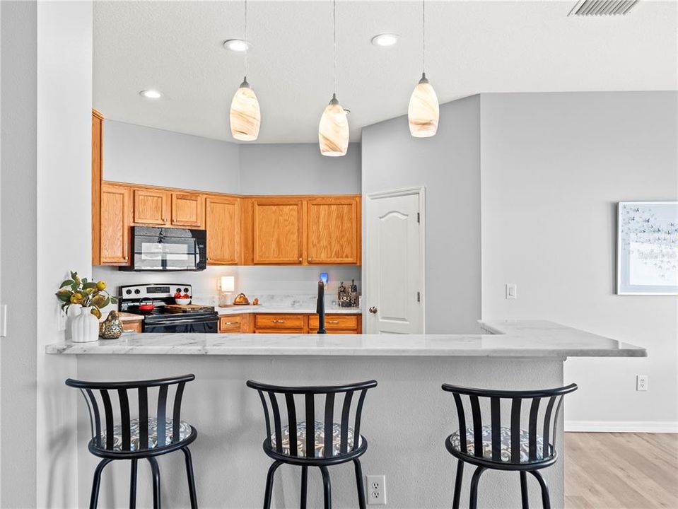 Breakfast bar opens the kitchen to both the eat in kitchen and family room