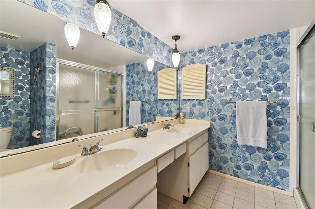 Primary bathroom has double sinks and a walk-in shower.