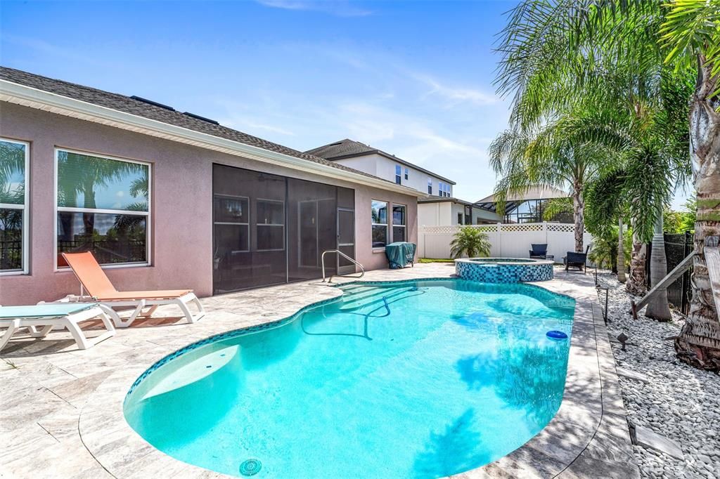 Saltwater pool with lush landscaping for privacy.