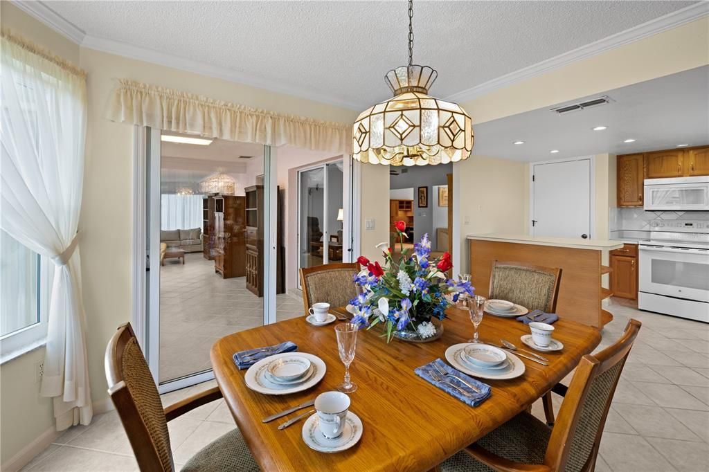 VIEW FROM THE BREAKFAST AREA TOWARDS THE FLORIDA ROOM AND KITCHEN ISLAND/PANTRY.