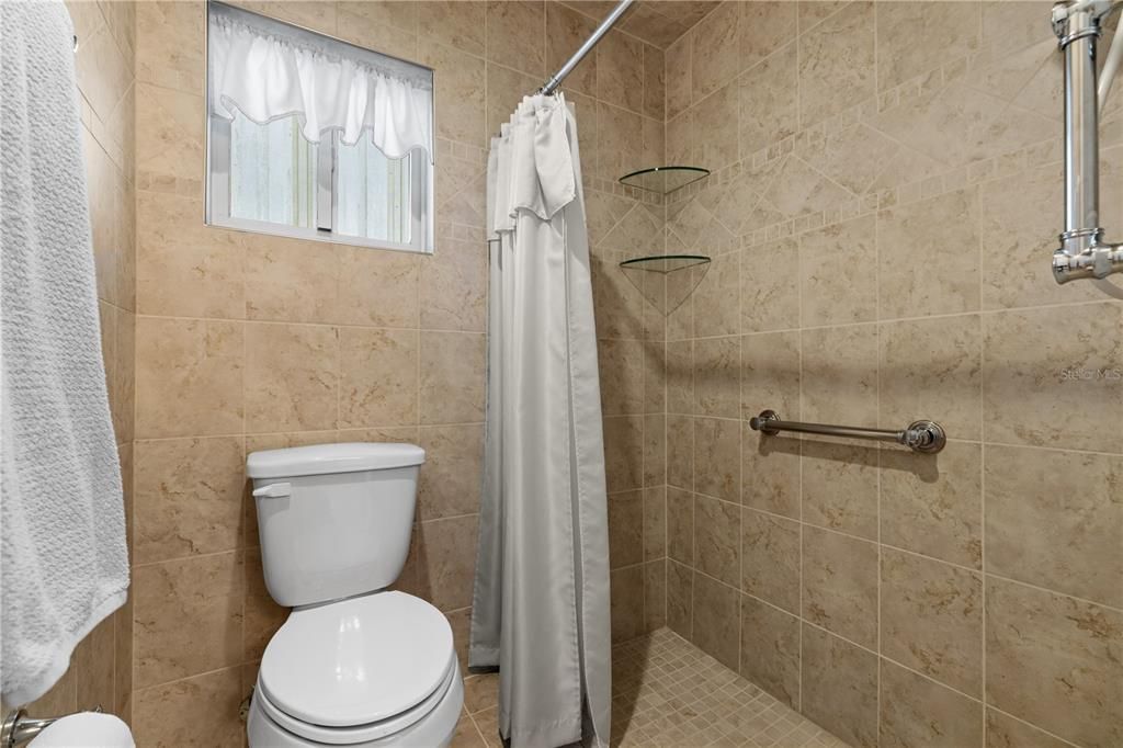 THE PRIMARY SHOWER HAS BEEN UPDATED WITH NEUTRAL COLOR CERAMIC TILE FLOORING, WALLS AND CEILING.