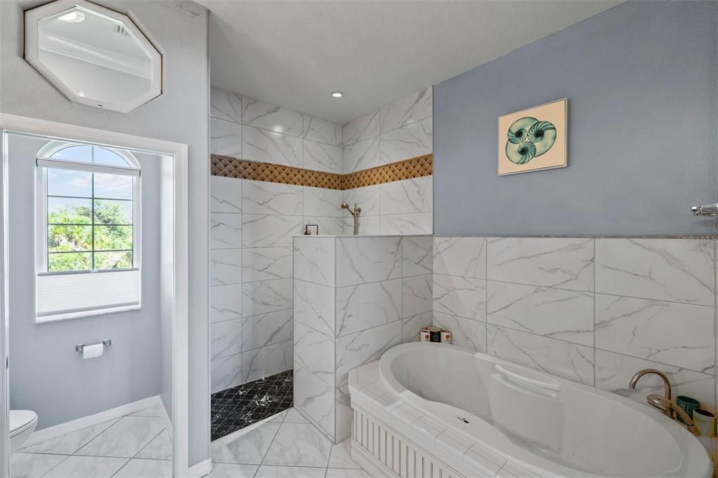 Primary en-suite bathroom showcases a separate whirlpool tub and walk-in shower.