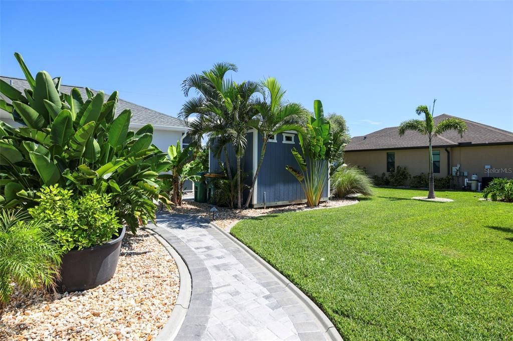 Mature landscaping surround the home and adds to the pathway to the garage and shed.