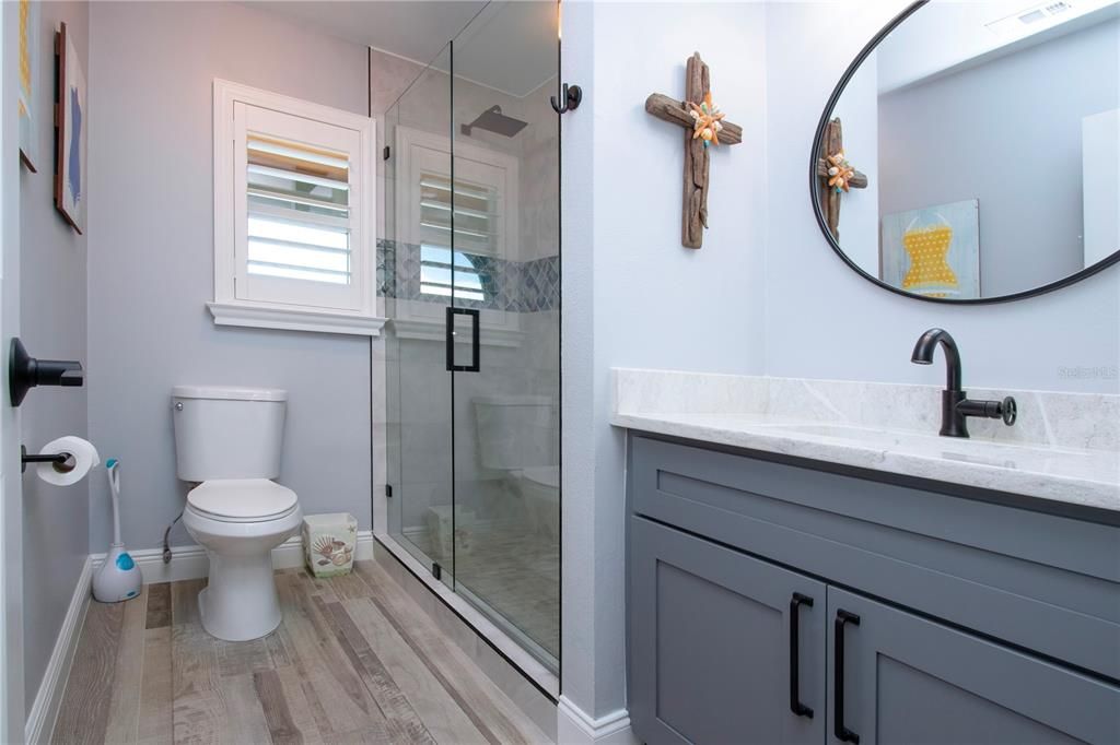 Remodeled Bathroom With Walk-In Tiled Shower and Glass Doors