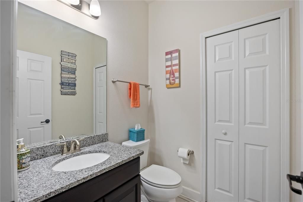 Half bathroom with large storage linen closet at the front of the home, by the den