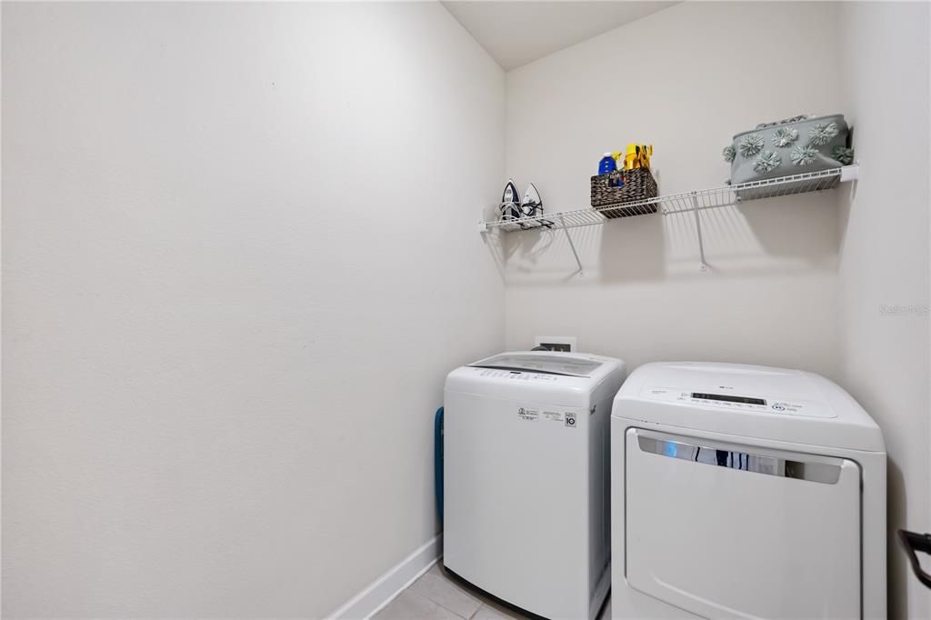 Utility room with washer and dryer hook up and shelving for storage