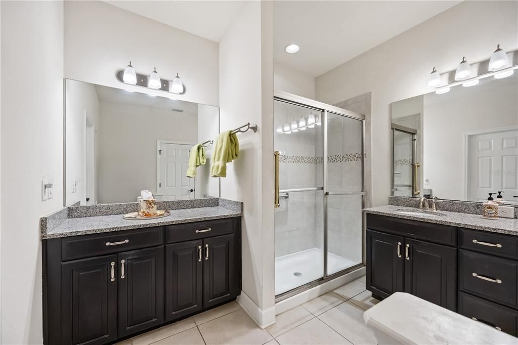 Large walk in shower with upgraded tile walls. Ensuite bathroom is equipped with a separate make up vanity and extra cabinet space