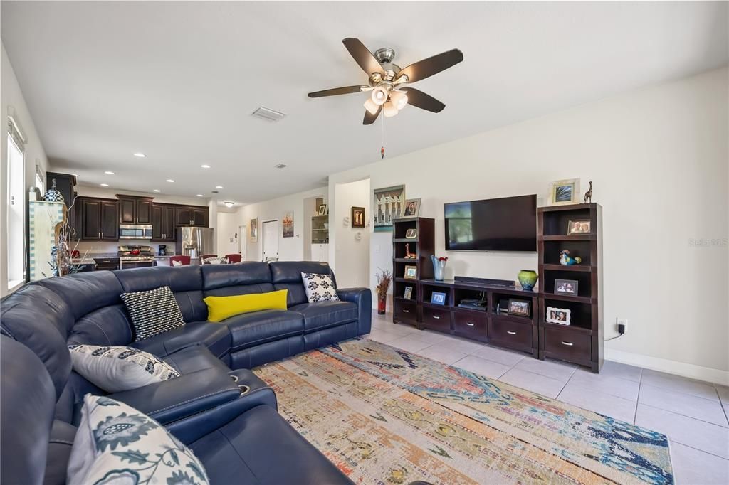 Large and spacious family room with a ceiling fan and ceramic tiles. Great size for hosting friends and family