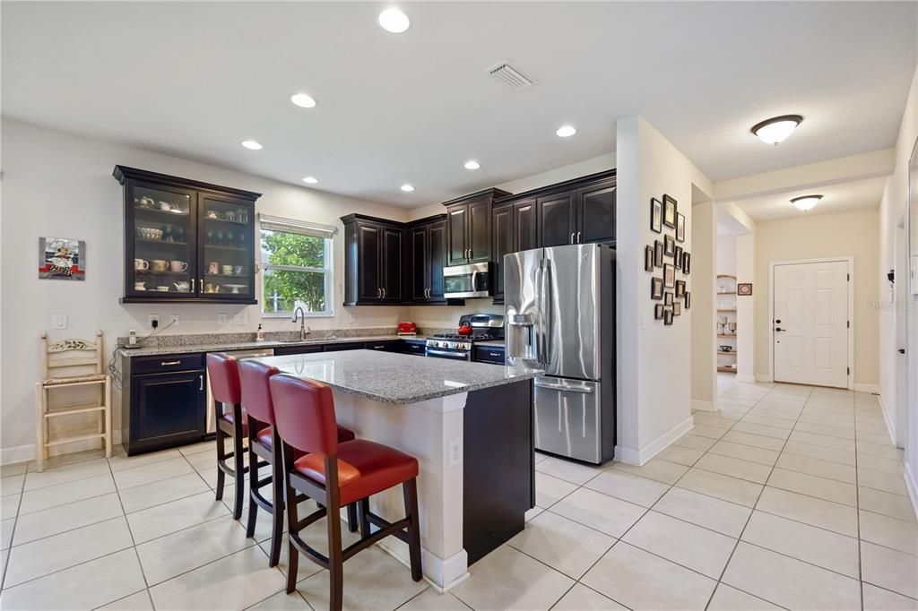 Spacious kitchen features granite counter tops, island, stainless steel appliances and plentiful storage inside 42" Cherry Java cabinets.