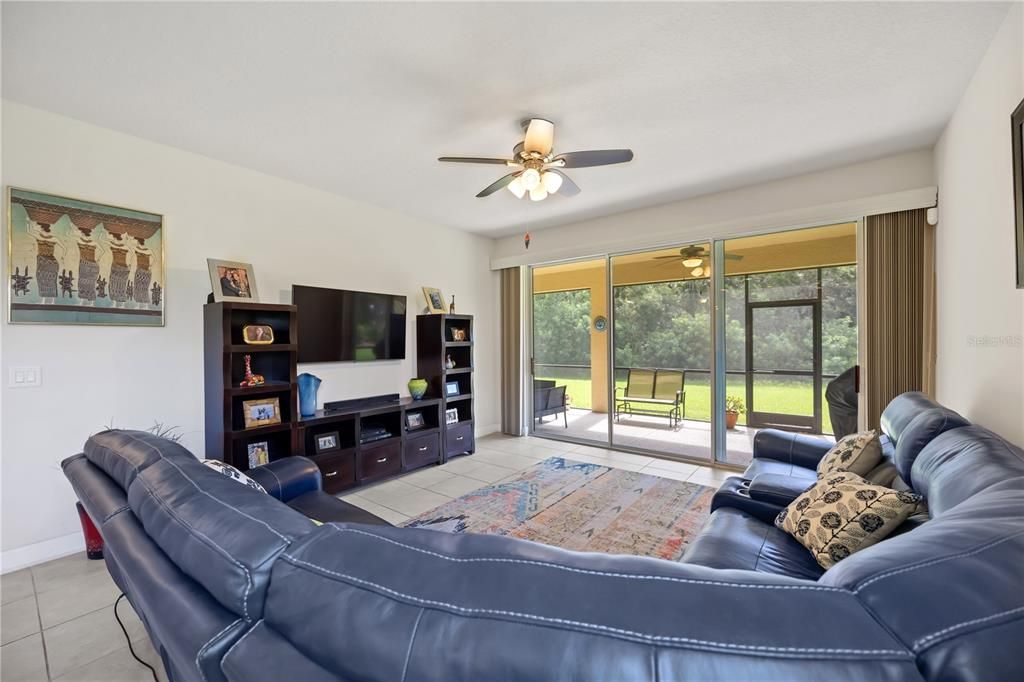 Family room equipped with triple sliding doors leading out to an oversized brick paver lanai with gas grill hook up for grilling that delicious meals year round in Paradise