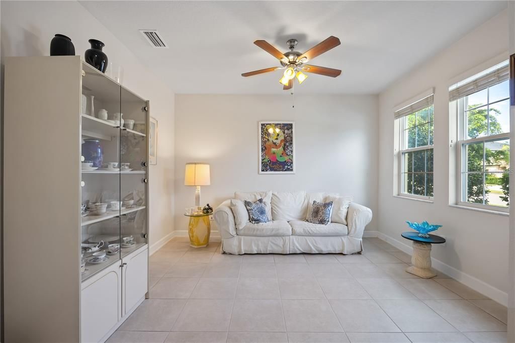 Large open Florida room in front of home with ceiling fan/overhead lighting and large window bringing in plenty of natural light