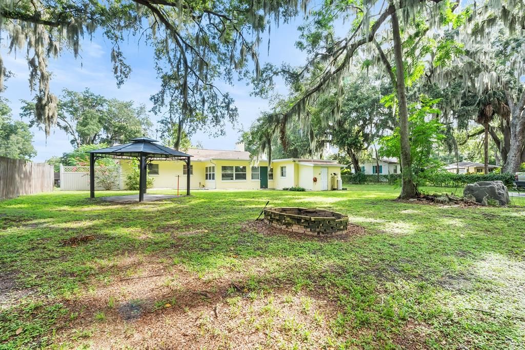 Gazebo with firepit in the backyard. There is also a 12x20 parking pad off to the right.