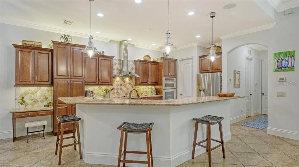 Gourmet kitchen featuring granite countertops, wood cabinets, built-in stainless steel appliances, and more!