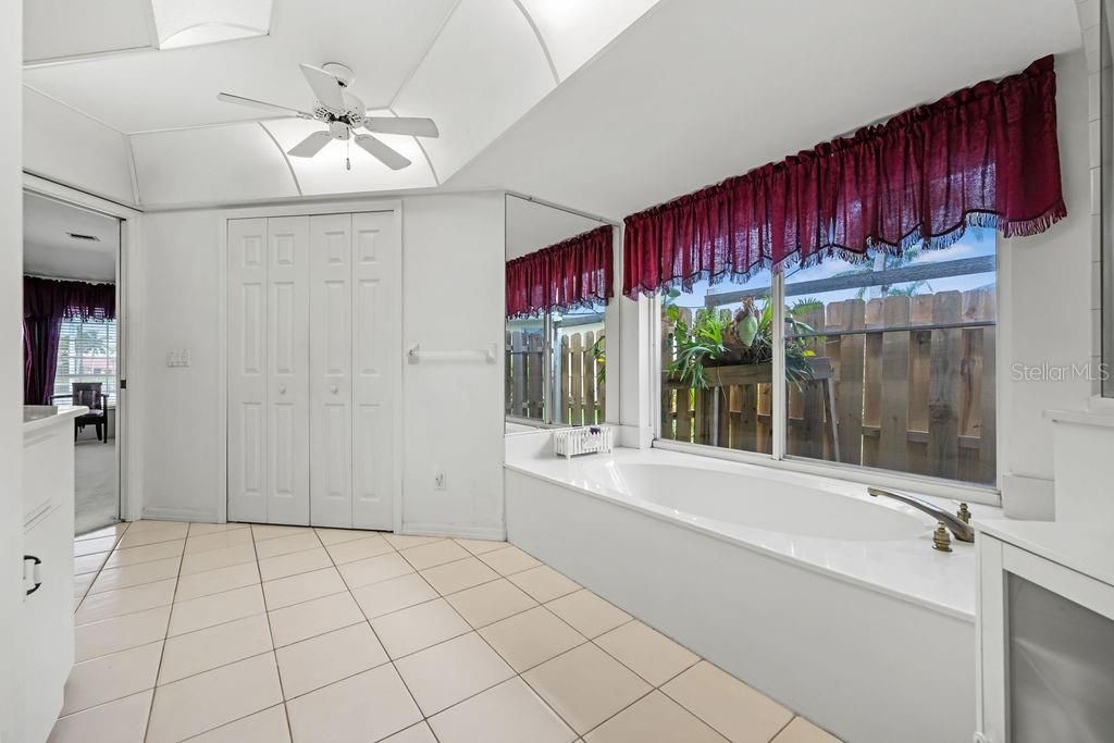 Primary bathroom with tub and walk-in closet. View to the primary bedroom.