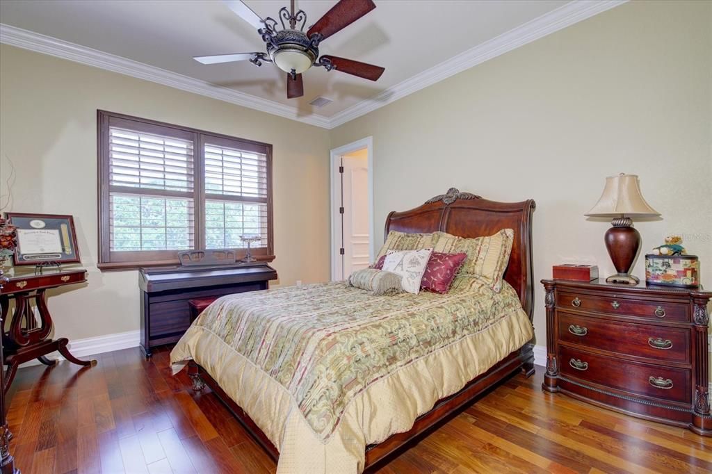 Bedroom 1 -all additional bedrooms feature cherry plantation shutters, ceiling fans, wood floors, custom walk-in closets, all with en suite bathrooms, granite countertops, wood cabinetry, tiled, & walk-in showers with glass doors