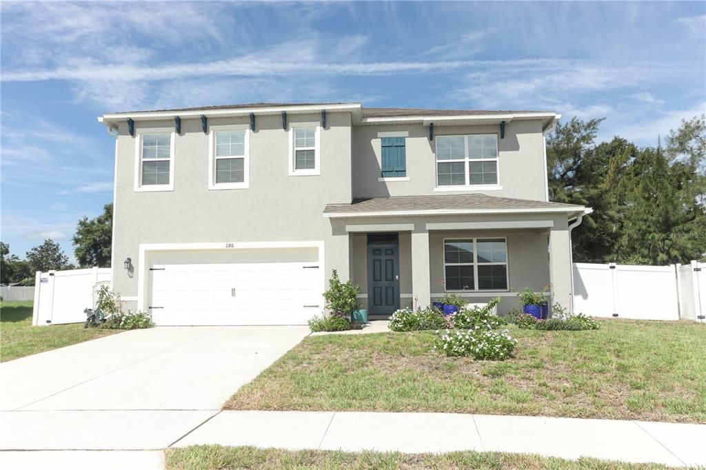 Front of home with large driveway and sidewalk