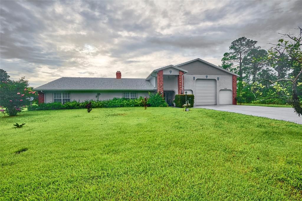 Front Exterior.  The lot is .75 acre.  Lots of room to park.  And look at that garage mahal!  There is a drain to empty your RV inside the garage.