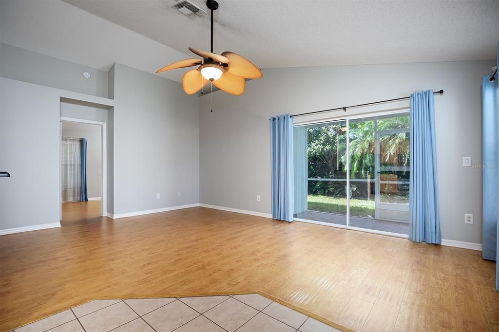 Open family room/kitchen/dinette floor plan leading out to addition screened in living space.