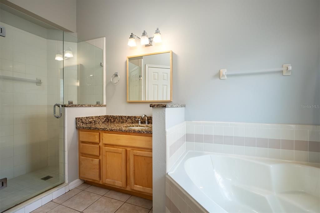 Spa-like master bath with a garden tub, spacious glass enclosed separate walk-in shower.