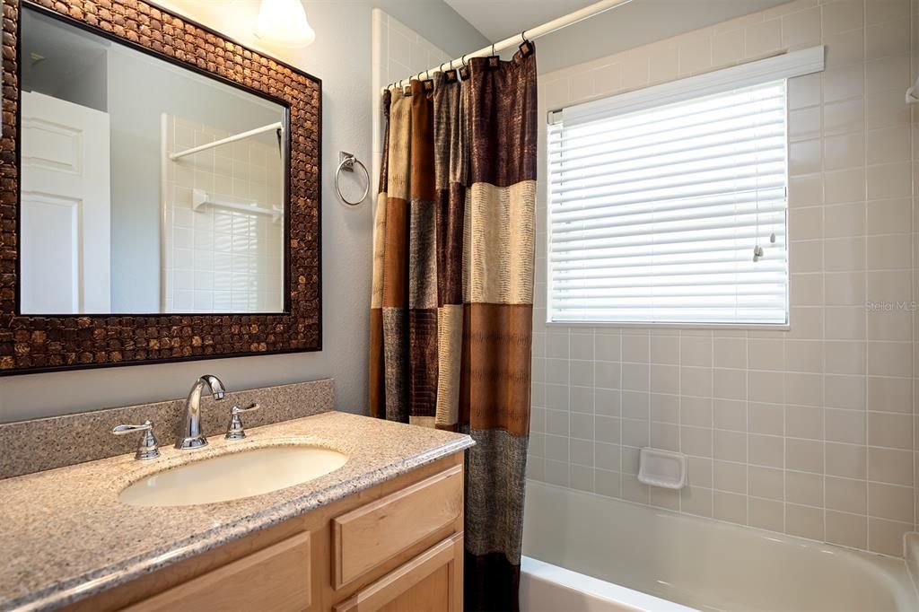 2nd bath with warm tones, granite counter, tub with shower. Perfect size for additional bathroom space.