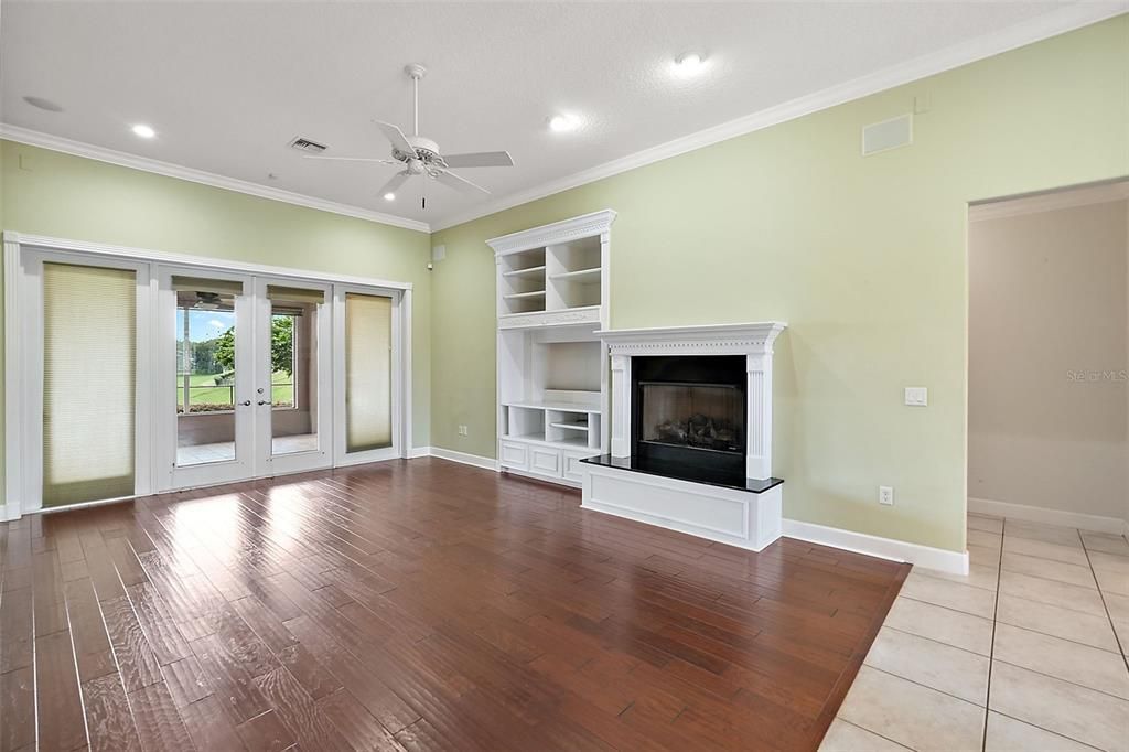 Living room has gas burning fireplace, built in shelving and French door entry to the spacious lanai