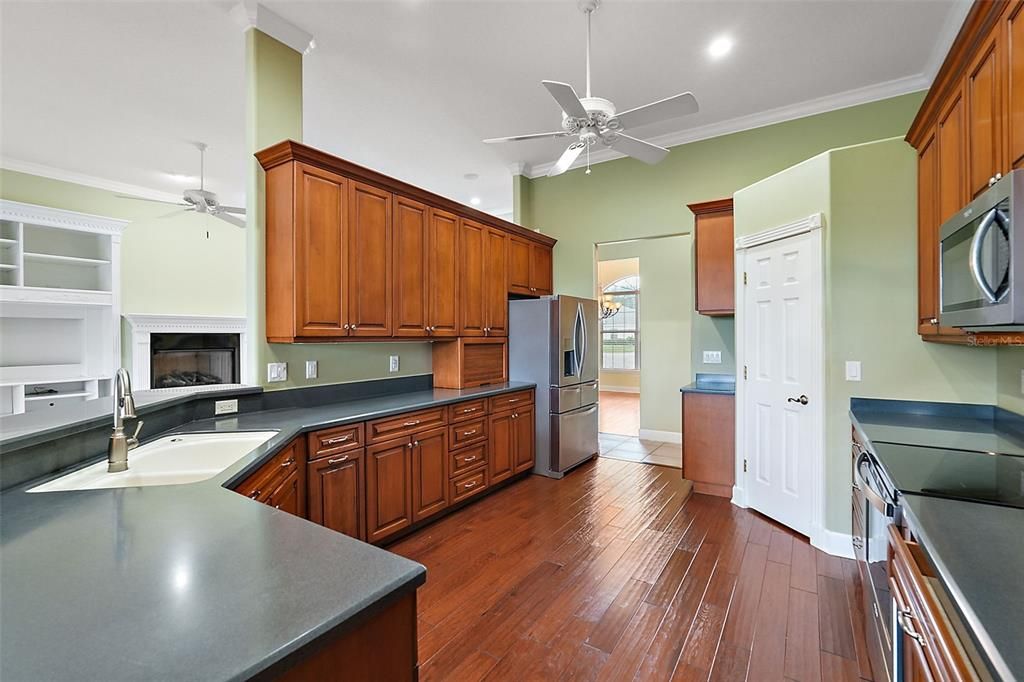 Well-appointed kitchen with gleaming wood floors and cabinetry, SS appliances, walk in pantry and small appliance garage