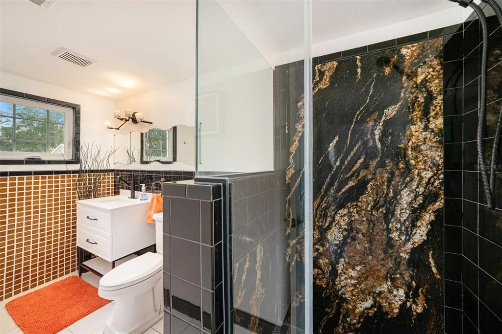 Private bath with exotic fire and black granite and double-glazed tiles.