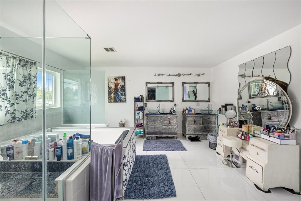 Ensuite bathroom adorned with sapphire granite, a spa tub and a glass enclosed shower.