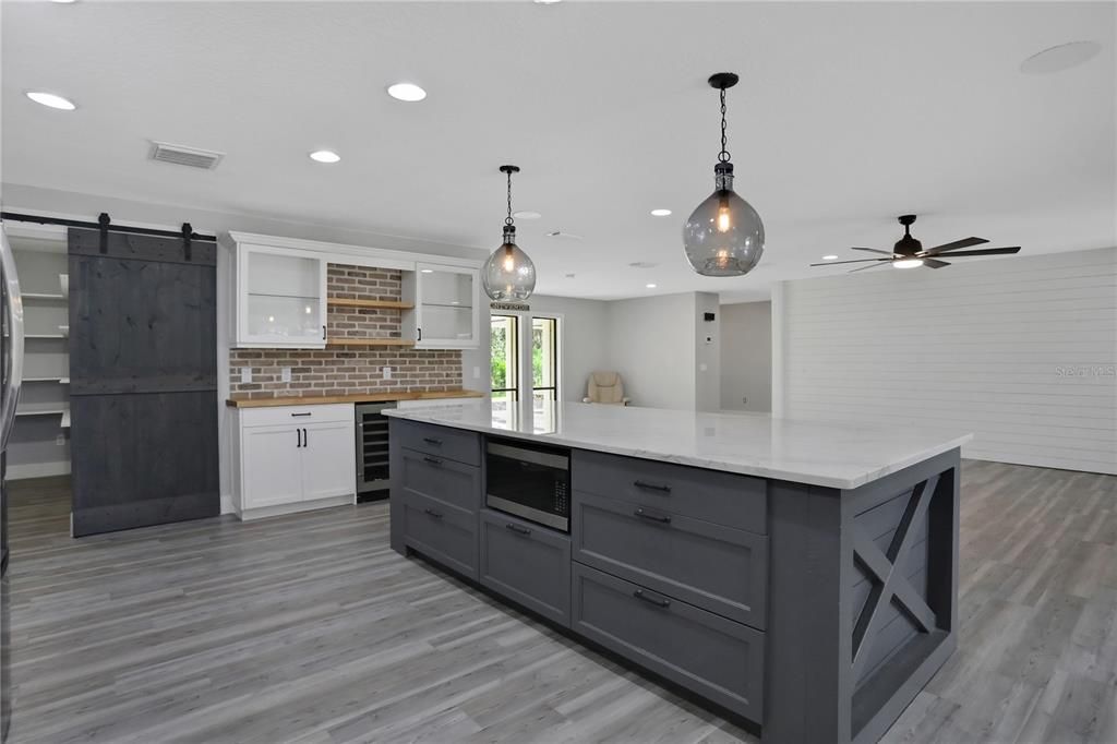 View of beautiful kitchen island and wet bar flowing into the family room