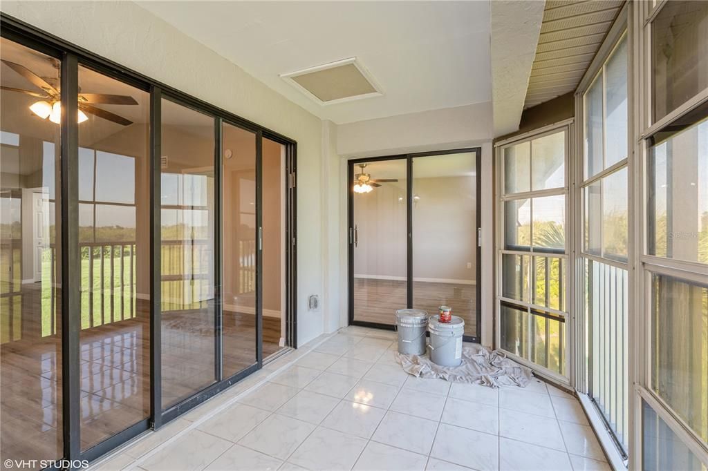 Light and bright lanai with tile flooring and screeneed in- sliders from living area and also prmary suite