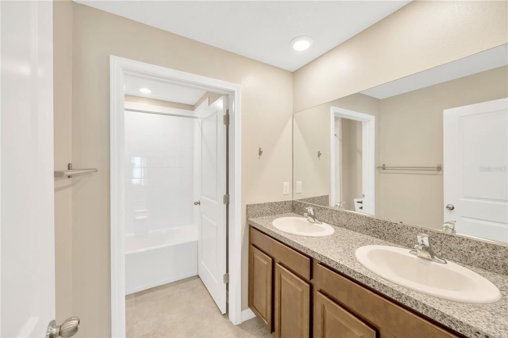 Secondary bedroom will share this full bathroom with long vanity and double sinks and separate shower/tub room.