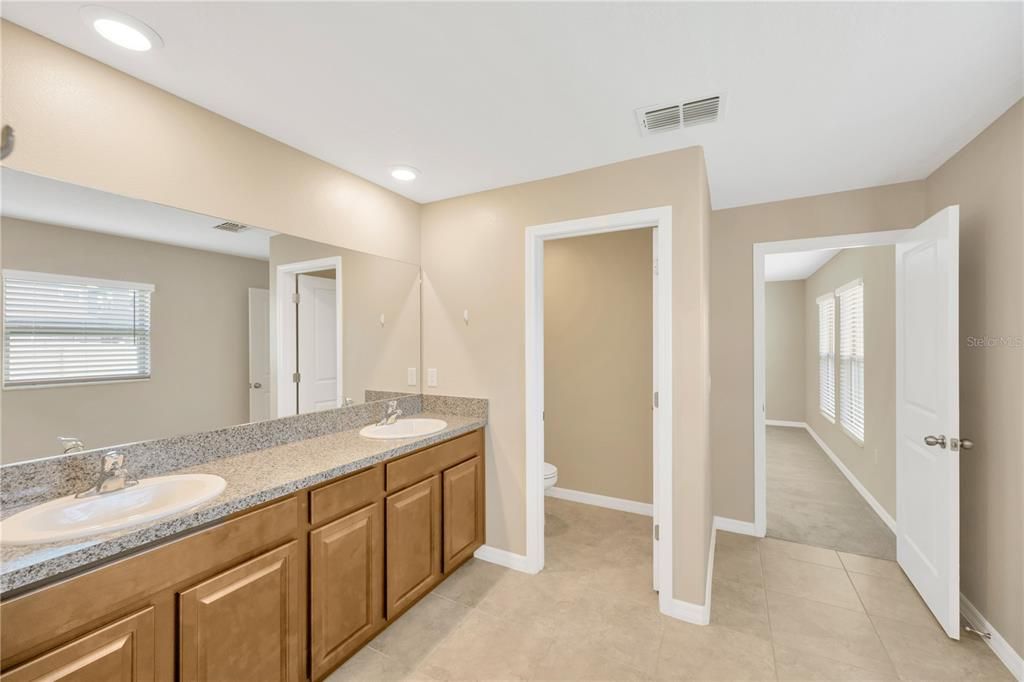 Owner's suite bathroom with Dual Sinks, Large walk-in shower, linen closet and W/C.