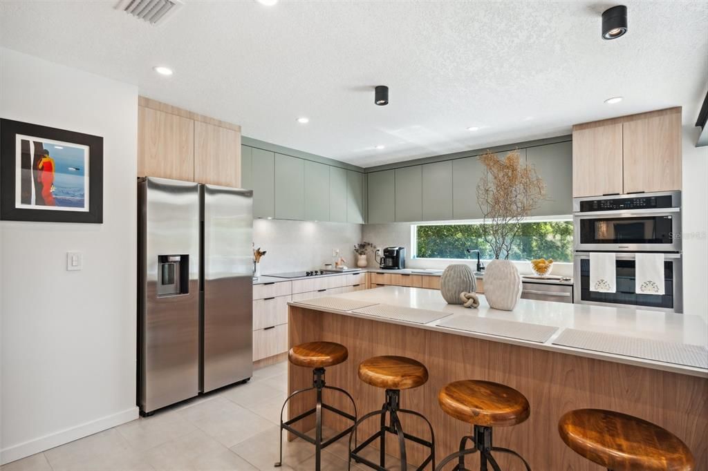 The kitchen features abundant cabinetry and new stainless steel appliances